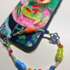 Tropical Fish phone charm attached to a phone with a colorful case