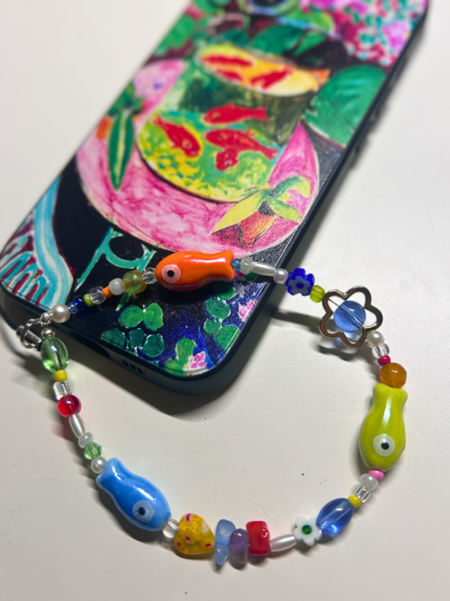 Tropical Fish phone charm attached to a phone with a colorful case